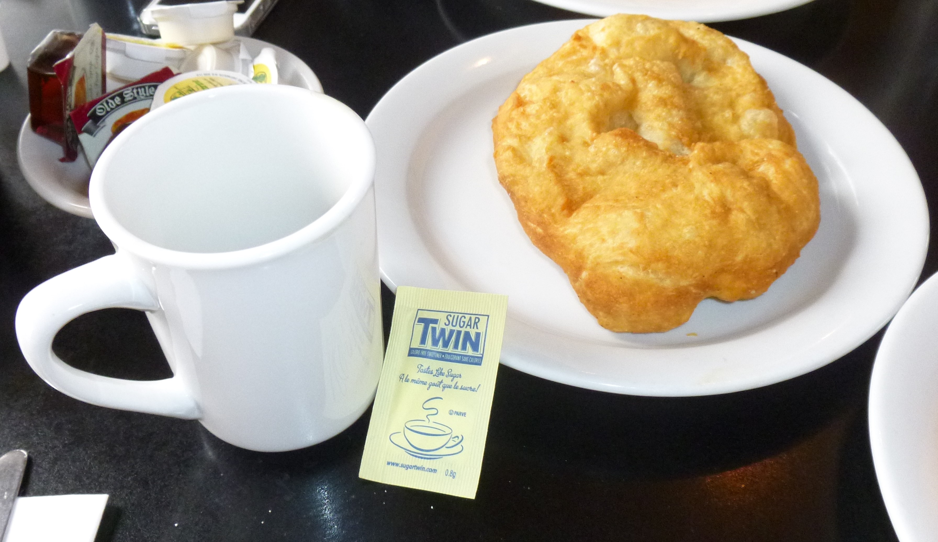 A touton on a plate with a mug of tea